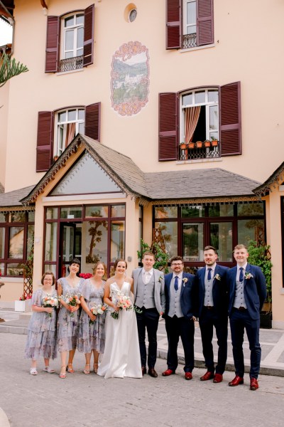 exterior wedding venue bride groom in the middle of bridesmaids and groomsmen outside wedding venue