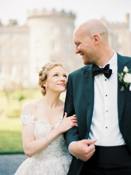 bride looks up to smiling groom