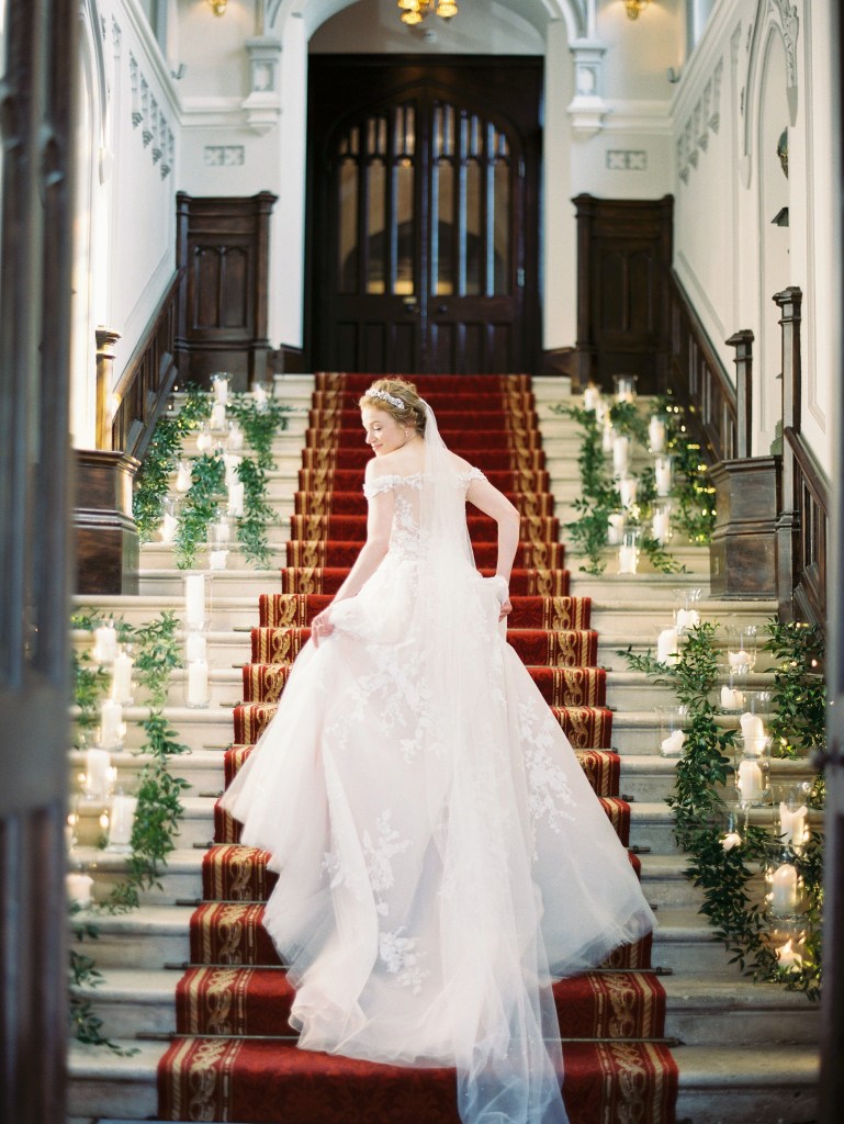 bride stands on red carpet lights candles lanterns placed on either side