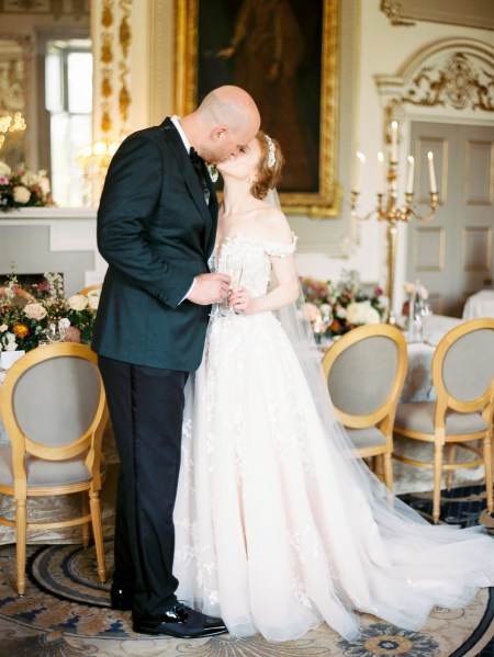 bride and groom kiss interior dining room setting