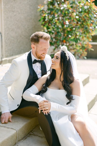 Bride and groom sit on the steps together