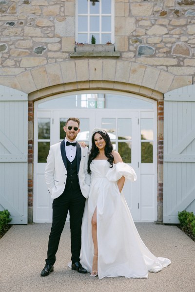 Bride and groom exterior shot pose for a photo