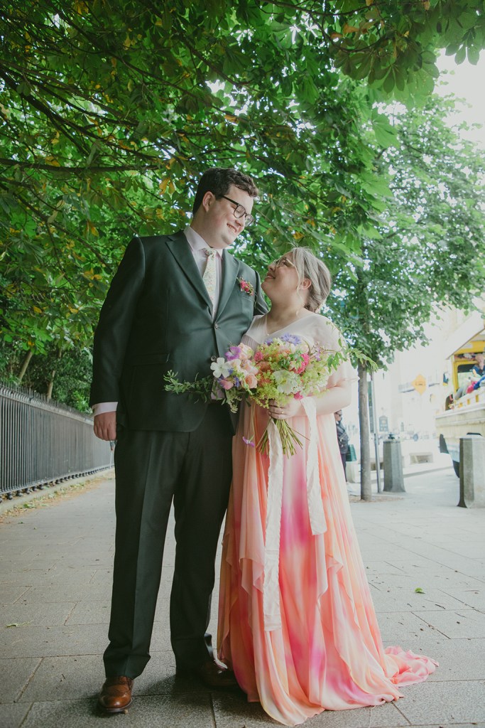 bride and groom stand beside Stephen's Green in Dublin facing each other