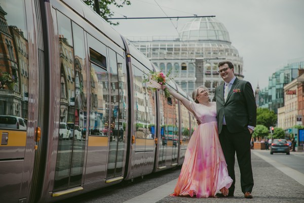 bride and groom outside Luas passing bouquet in the air