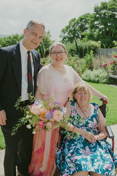 family photo of bride groom and mother seated