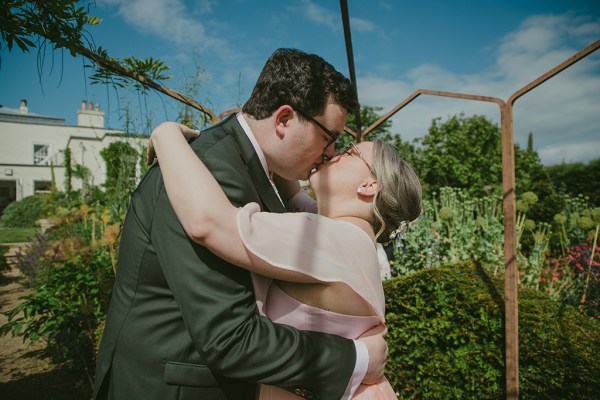 bride and groom kiss in garden setting