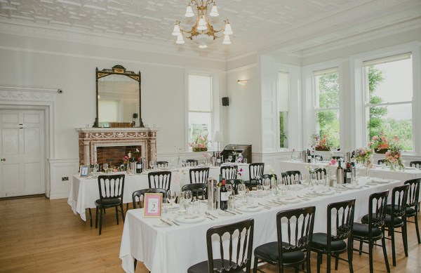 empty dining room setting with cutlery red wine in buckets glasses and flowers on table