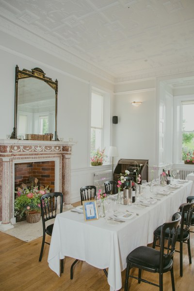 empty dining room setting with cutlery red wine in buckets glasses and flowers on table