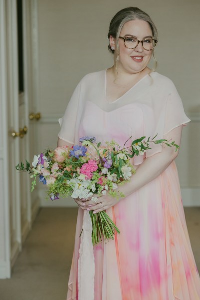 bride is ready she looks over shoulder holding bouquet