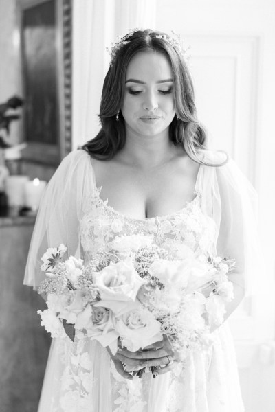 B&W of bride looking down at bouquet