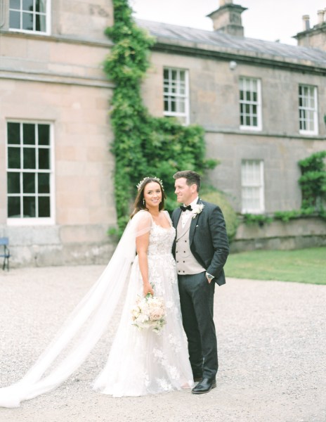 bride and groom stand in the courtyard together