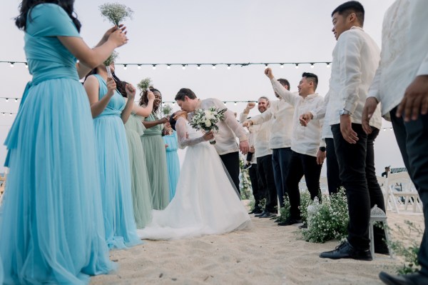 bridesmaids and groomsmen on either side of bride and groom who kiss in the middle