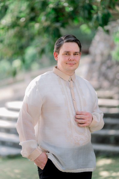 groom wearing earring smiles for the camera