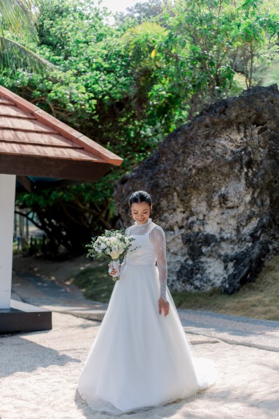 bride looks down as she holds bouquet