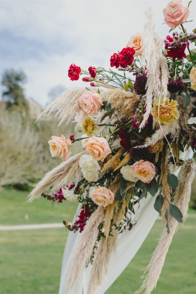 bride holds bouquet in garden rose red pink flowers