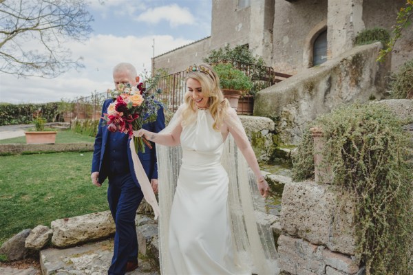 father of the bride walks his daughter towards wedding car