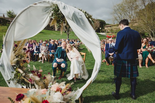 bride and groom laughing a lot at alter to ceremony guests behind them