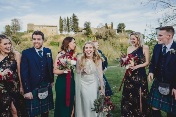 bride and bridesmaids pose together in farm grass setting