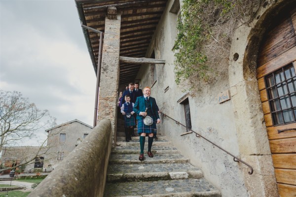 groom in kilt is ready for wedding he walks down the steps with his groomsmen