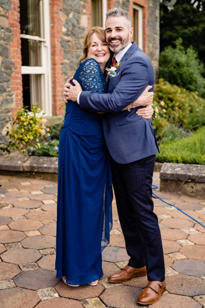 mother and son groom hugging in courtyard