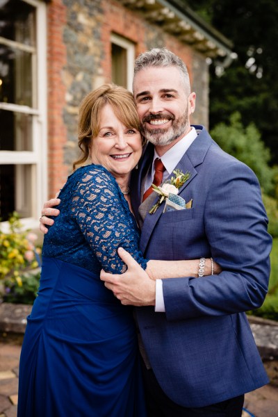 mother and son groom hugging in courtyard