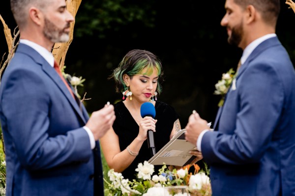 grooms stand at alter with celebrant reading speech or sermon