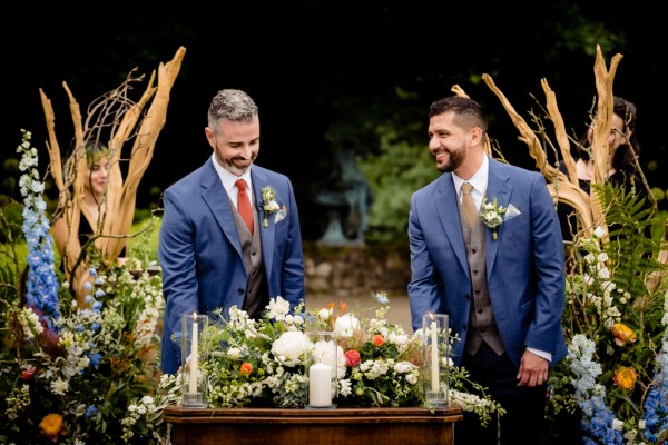 grooms about to sign the marriage certificate they smile at table