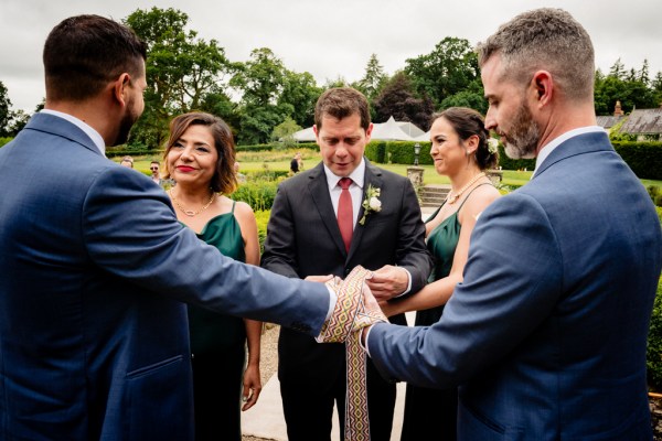 grooms are bound by ribbon bridesmaids and witnesses