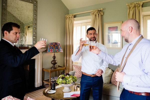 groom inside room interior with groomsmen as they cheers