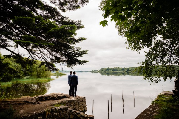 grooms walk along stony boardwalk to lake