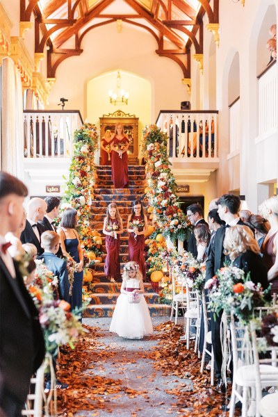 Little flower girl walks down the aisle