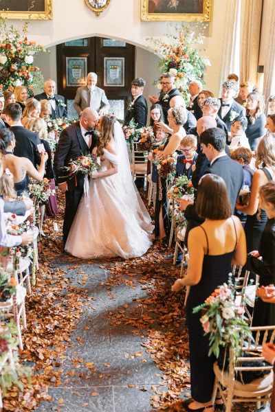 Bride and groom exit ceremonial room guests clapping