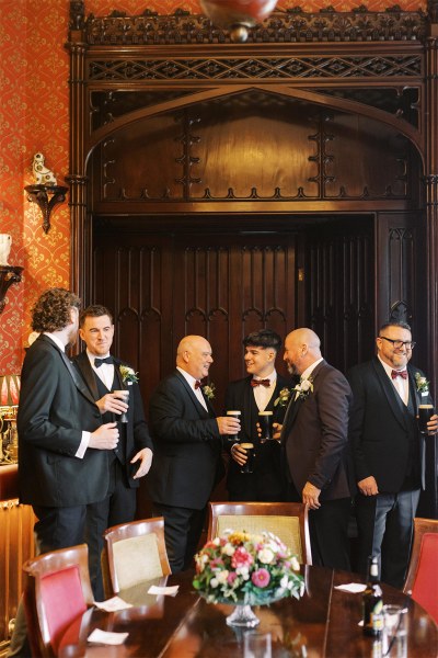 Groom and groomsmen drinking pints of Guinness/beer