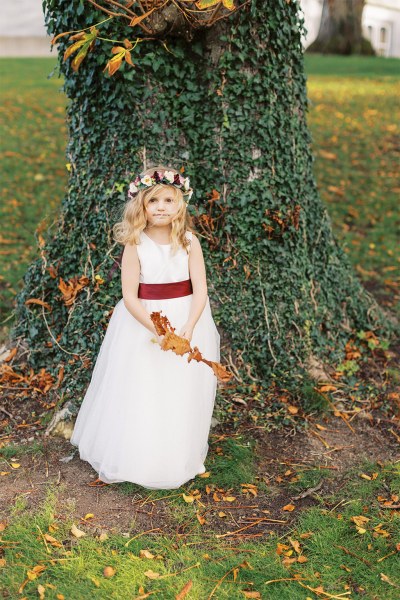 Little girl plays outside beside the tree in garden park