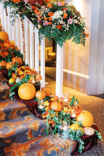 Pumpkins autumnal theme orange flowers laid out on stairs