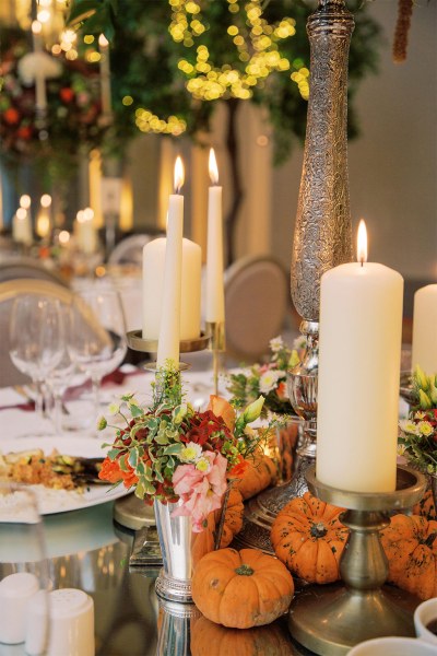 Candles lit on table flowers glasses