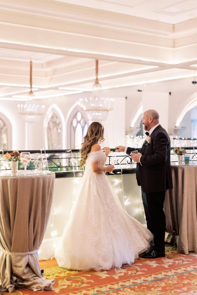 Bride and groom stand at balcony together