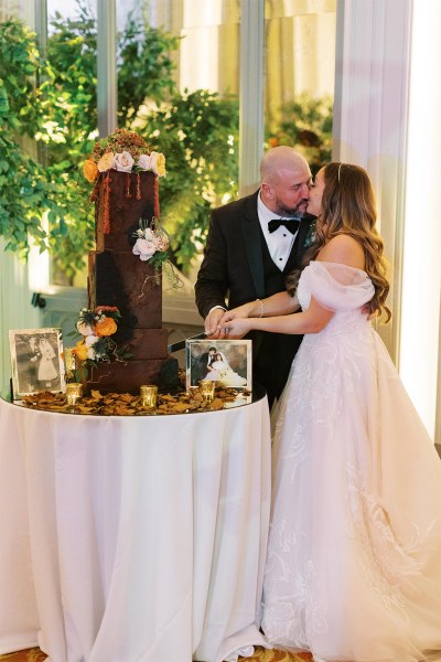 Bride and groom cut the cake and kiss