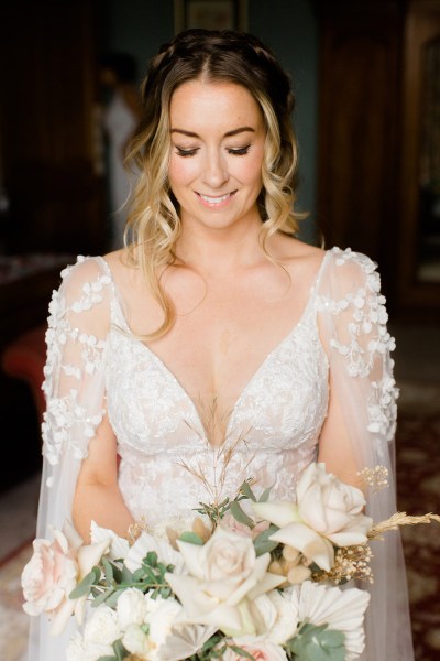 bridesmaid looks down at bouquet flowers smiling