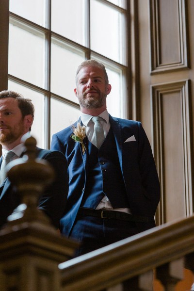 man in suit on top of staircase