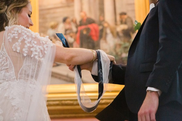 bride and groom bound with ribbon at alter