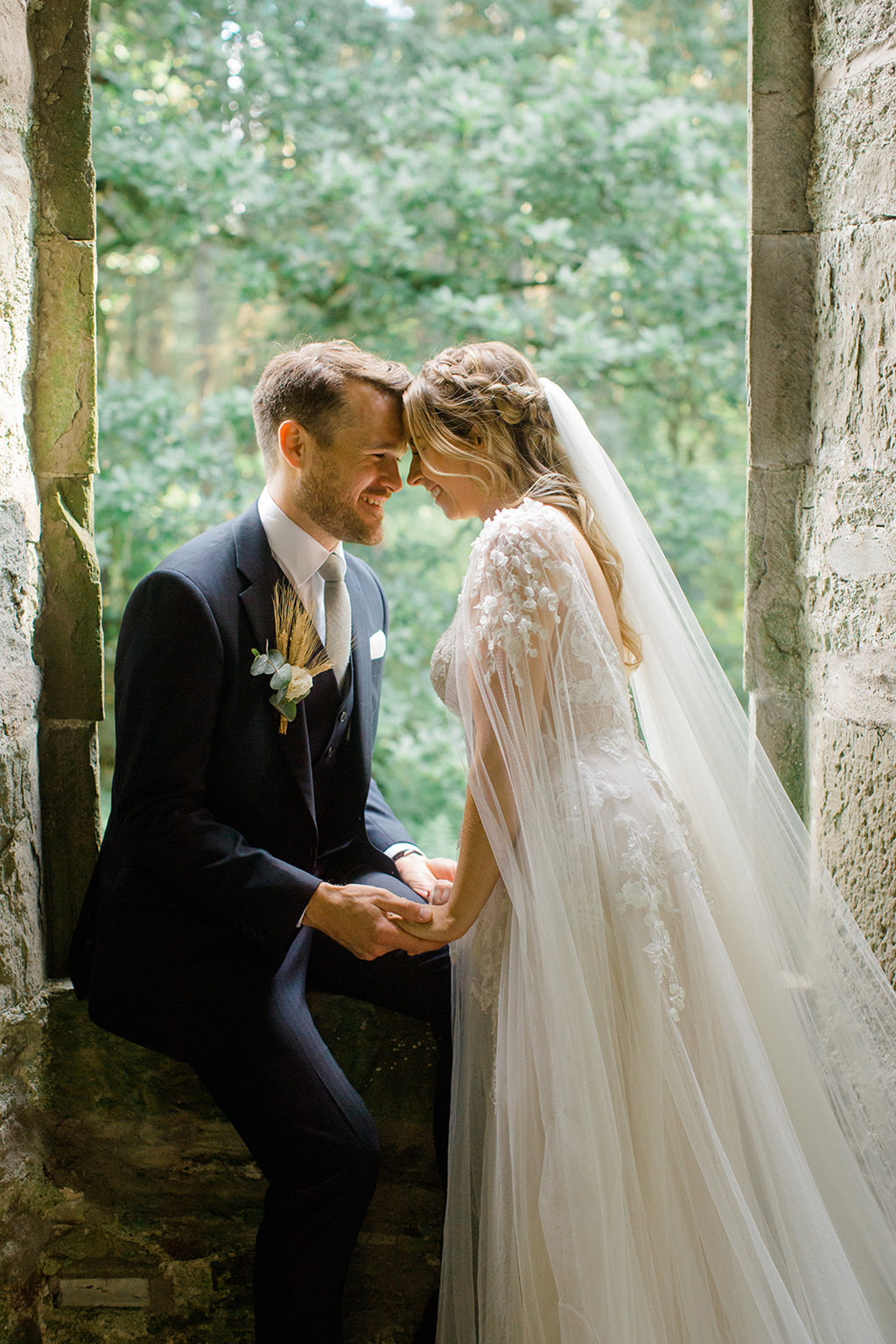 bride and groom touch foreheads in garden setting