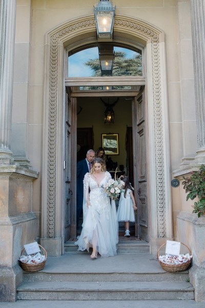 bride exits church entrance with little girls behind her