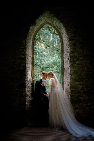 archway setting forest garden bride and groom kissing