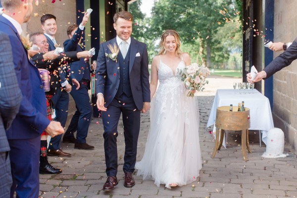 bride and groom confetti being thrown over them by guests