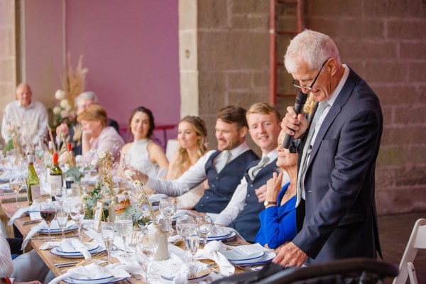 father gives speech guests bride and groom smiling