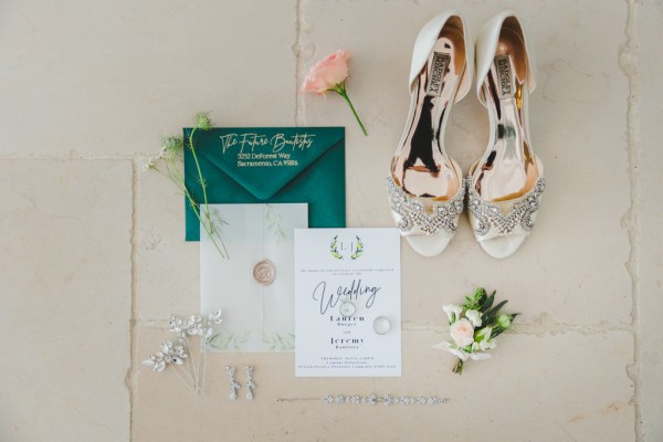 Green and white stationary on tiles with embellished heels and a pink flower