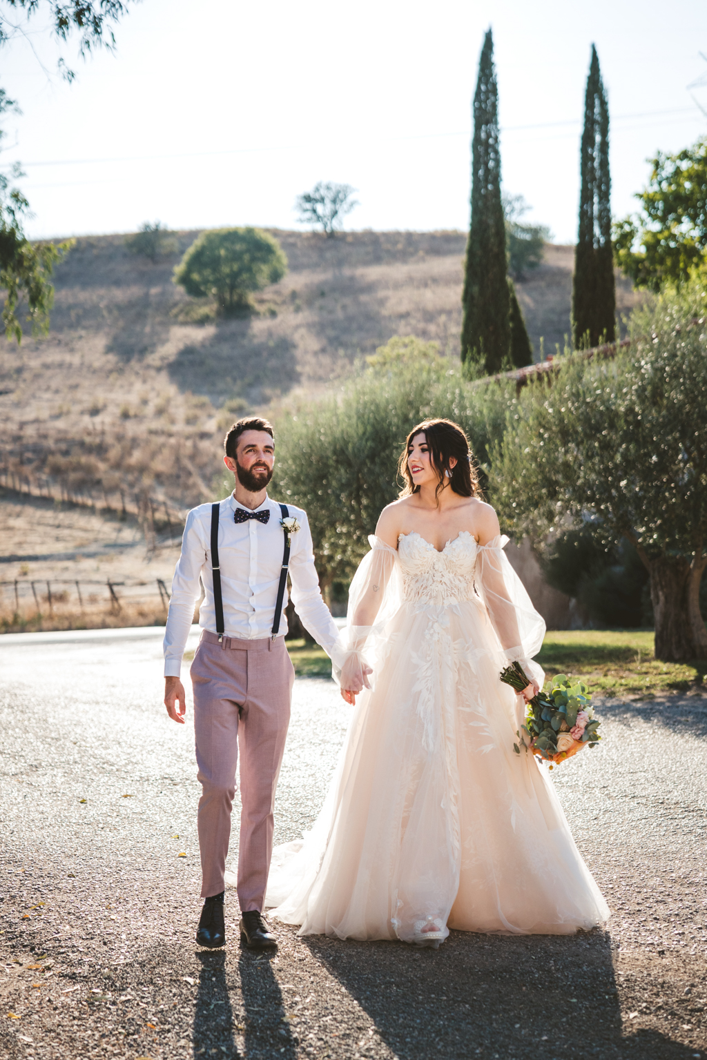 bride and groom walk in the courtyard pathway hand in hand