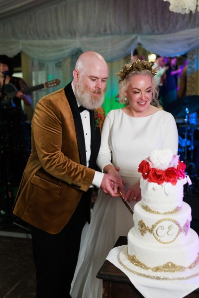 bride and groom cutting the white wedding cake