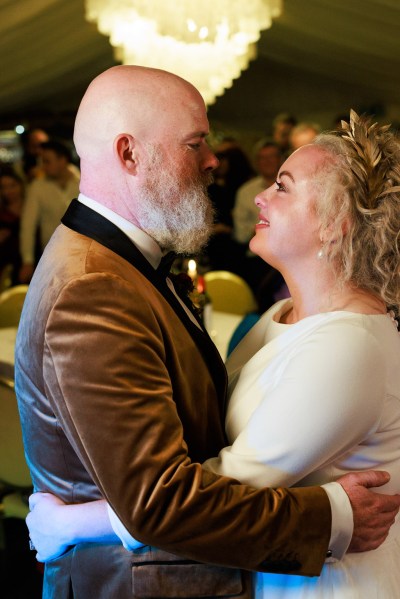 bride and groom dance on the dancefloor smiling at each other